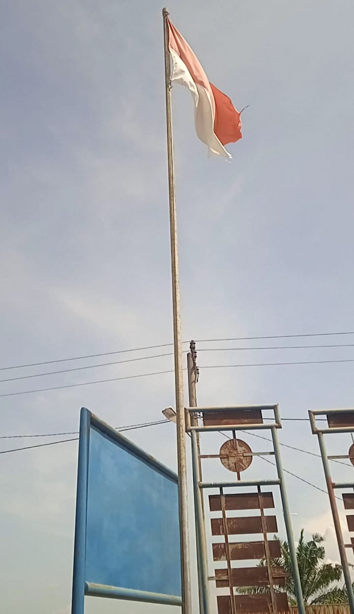 Bendera Merah Putih Robek, Kusam, Buram, Berkibar Di Kantor Balai Desa Sei Raja Kec. Medang Deras Kab. Batu Bara Sumut.